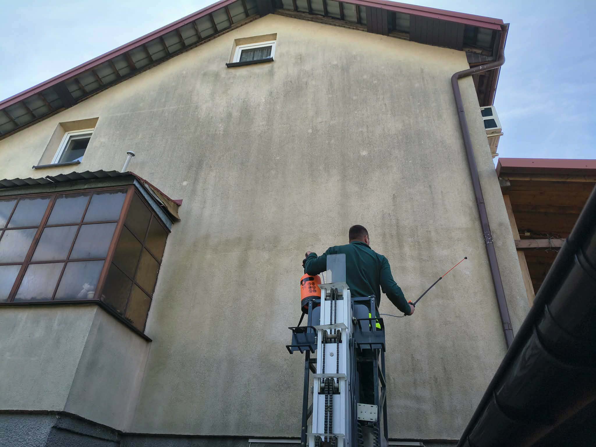 Operator podnośnika przygotowujący elewację do czyszczenia